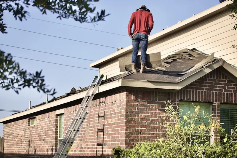 Professional roofer working on a residential roof in Highbank